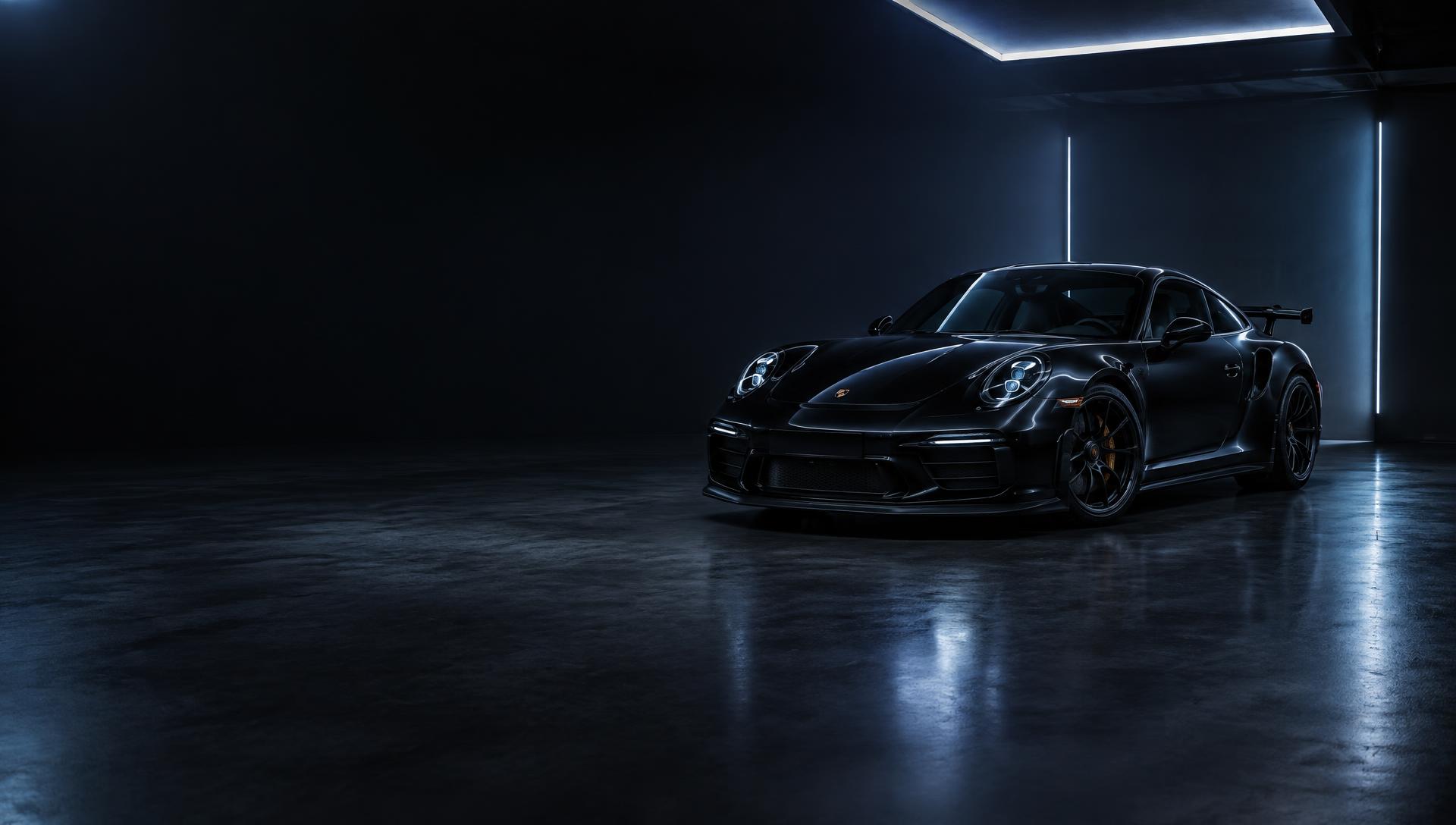 Black luxury performance car in a dark studio with cool blue light